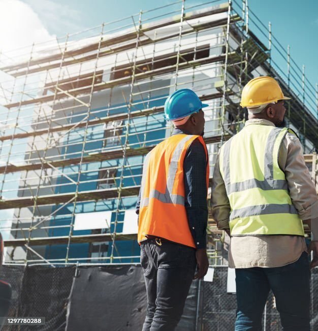 shot of a group of builders assessing progress at a construction site shot of a group of builders assessing progress at a construction site